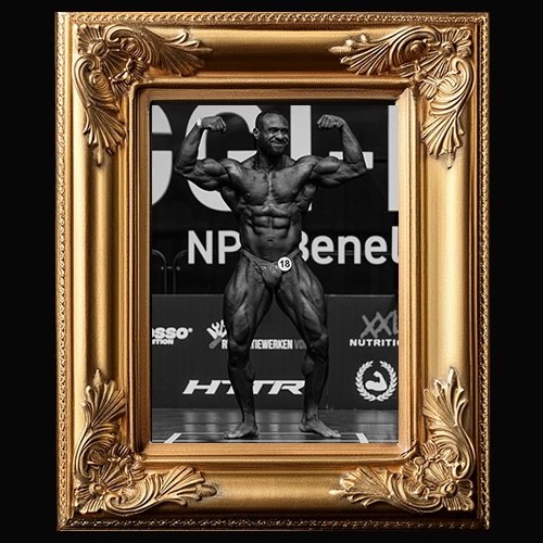 Chellten Winklaar toont zijn gespierde fysiek tijdens zijn eerste bodybuildingwedstrijd, omlijst in goud.